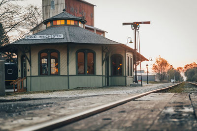 View of railroad tracks by building against sky