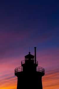 Low angle view of silhouette lighthouse against sky during sunset