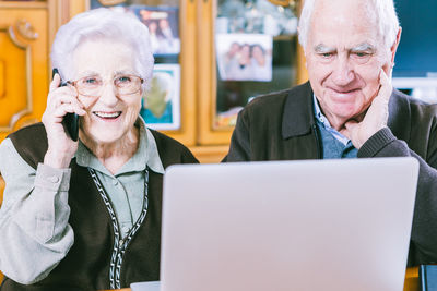 Portrait of smiling man sitting on laptop