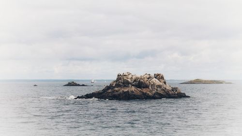 Rock formation in sea against sky