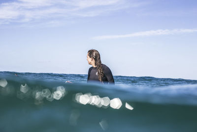 Woman swimming in sea against sky