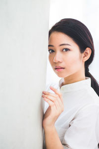 Portrait of young woman against white background