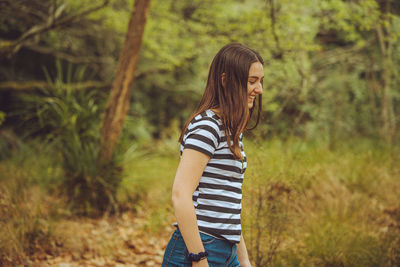 Young woman standing in forest