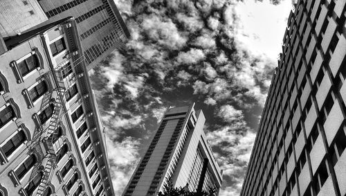 Low angle view of modern building against cloudy sky