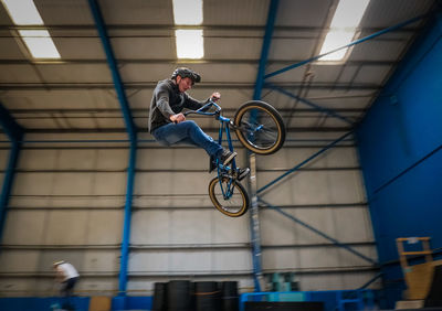 Low angle view of man holding bicycle