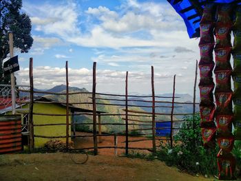 Close-up of railing by fence against sky