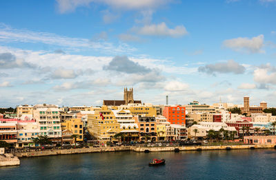 Buildings in city against cloudy sky