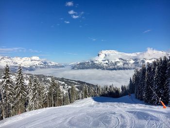 Scenic view of snowcapped mountains against blue sky