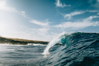 Scenic view of waves in sea against sky