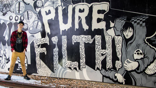 Man standing on graffiti wall