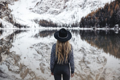 Rear view of woman standing against lake