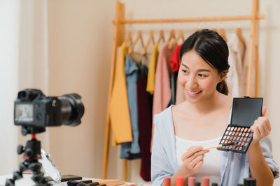 Portrait of woman holding camera