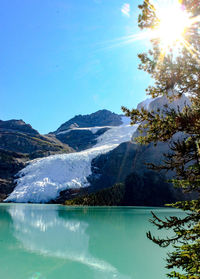 Scenic view of lake and mountains against clear blue sky