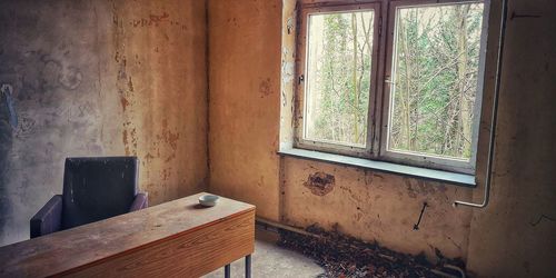 Empty chairs and table against window at home