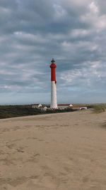 Lighthouse by sea against sky