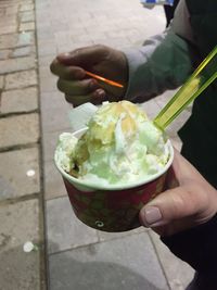 Close-up of hand holding ice cream in bowl