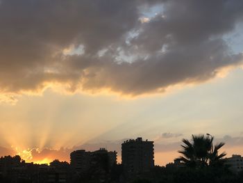 Silhouette buildings against sky during sunset