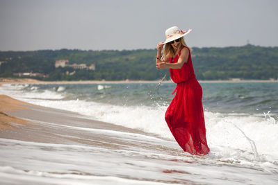 Woman wearing hat while standing on beach