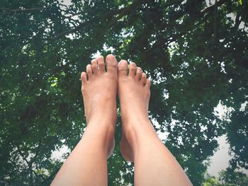 Low section of woman legs against trees