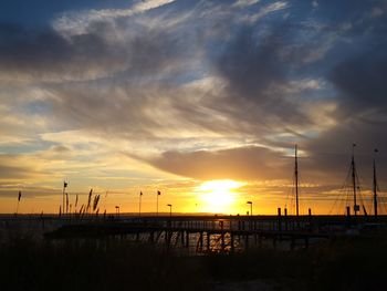 Scenic view of sea against dramatic sky during sunset