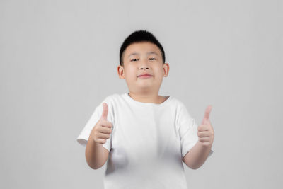 Portrait of boy standing against white background