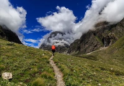 Rear view of person on mountain against sky