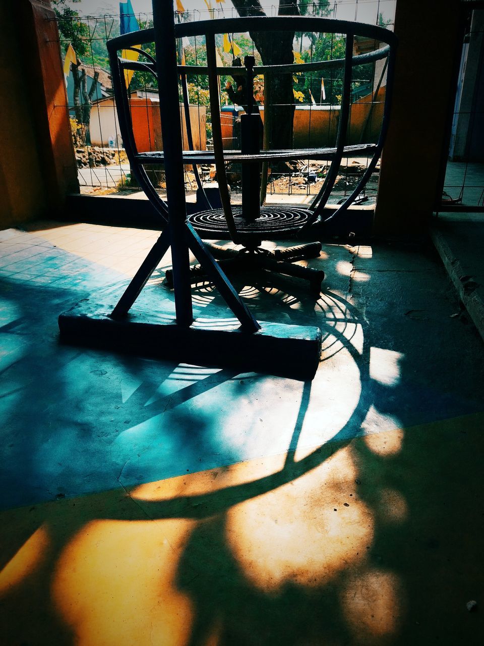 EMPTY CHAIRS AND TABLE IN SUNLIGHT