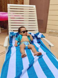 Full length of baby boy relaxing on lounge chair