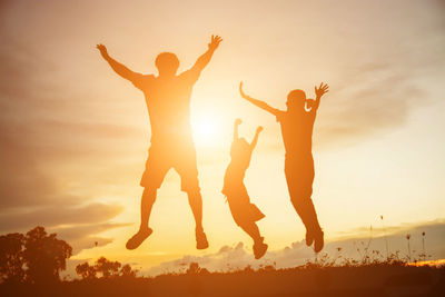 Low angle view of silhouette friends against sky during sunset