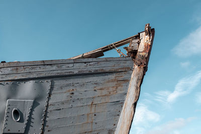 Low angle view of rusty metal against sky