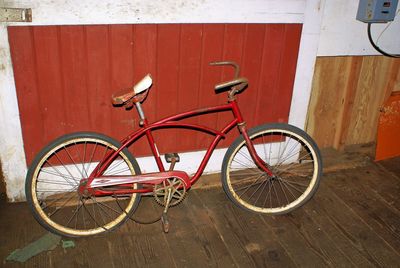 Bicycle parked against wooden wall