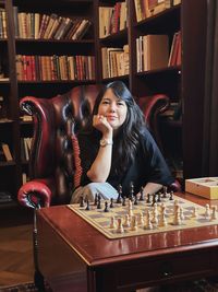 Portrait of young woman playing chess