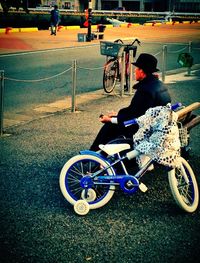 Rear view of man riding bicycle on road