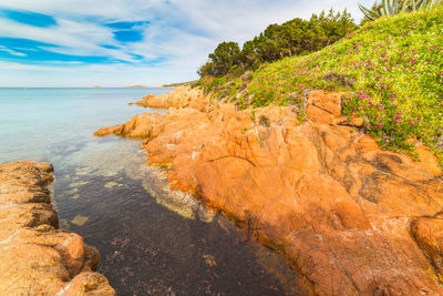 Rock formations by sea against sky