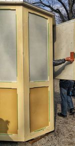 Low section of man standing by window