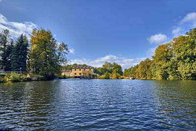 Scenic view of lake by trees against sky