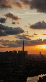 Modern buildings against cloudy sky during sunset