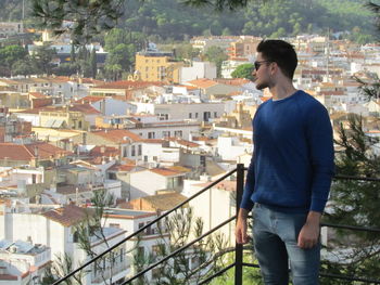 Full length of young man looking at city buildings