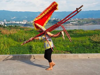 Low angle view of traditional windmill on field against sky