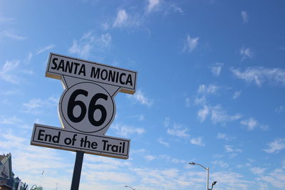 Low angle view of road sign against sky