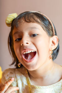 Close-up portrait of cheerful girl wearing headband at home