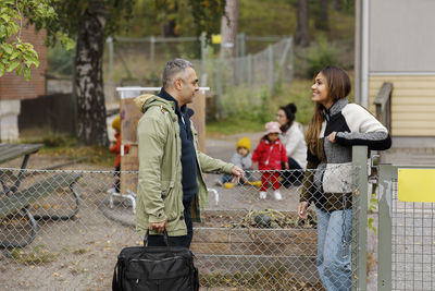 Man and woman talking at gate