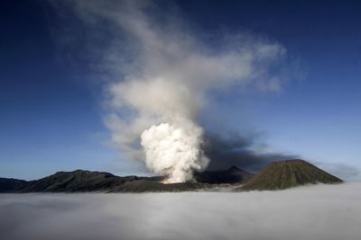 Smoke emitting from volcanic mountain against sky