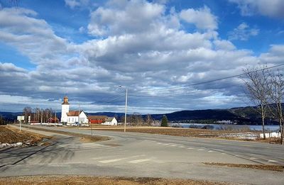 Empty road against cloudy sky