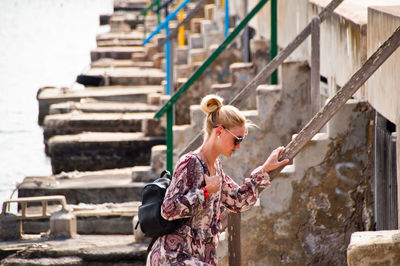 Young woman standing against wall