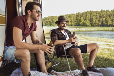 Friends drinking beer while camping