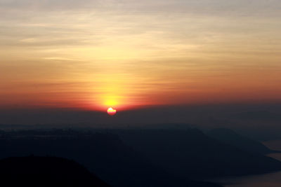 Scenic view of silhouette mountains against sky at sunset