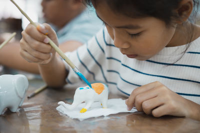 Cute girl making decoration on table