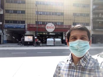 Portrait of man standing on street in city