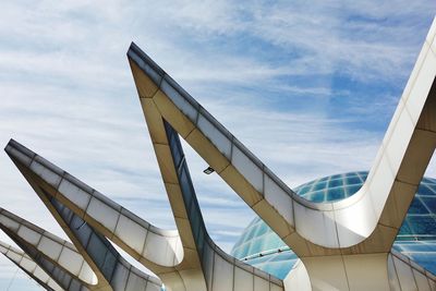 Low angle view of modern building against cloudy sky